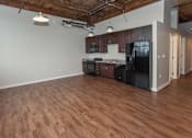 Thumbnail 3 of 25 - A kitchen with black appliances and wooden floors at Spaulding Lofts Apartments, Grinnell, Iowa