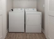 Thumbnail 8 of 25 - A white washing machine and dryer in a small laundry room at Spaulding Lofts Apartments, IA, 50112