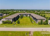 Thumbnail 24 of 35 - A large, modern building with a long, wide lawn in front.