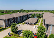Thumbnail 26 of 35 - A large apartment complex with a parking lot in front.