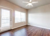 Thumbnail 11 of 35 - A room with a ceiling fan and wooden flooring.