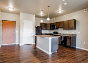 Thumbnail 5 of 35 - A kitchen with a wooden floor and a white island.