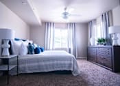 Thumbnail 12 of 35 - A bedroom with a bed, nightstand, and dresser.