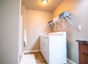 Thumbnail 14 of 35 - A white washing machine in a laundry room.