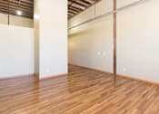 Thumbnail 1 of 13 - A room with wooden flooring and white walls.at Riverpoint Lofts, Des Moines  