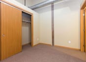 Thumbnail 3 of 13 - A room with a brown carpet and a wooden door.at Riverpoint Lofts, Iowa   