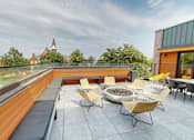 Thumbnail 18 of 27 - a rooftop terrace with chairs and tables and a fire pit at Canary Lofts, Des Moines, 50311