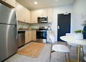 Thumbnail 1 of 27 - a kitchen with stainless steel appliances and a table and chairs at Canary Lofts, Des Moines