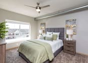 Thumbnail 7 of 31 - a bedroom with a large bed and a ceiling fan at Lake Shore Apartments, Iowa, 50021