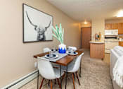 Thumbnail 10 of 22 - our apartments offer a dining room table with chairs and a view of the kitchen at Lake Shore Park, Iowa