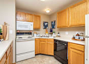 Thumbnail 7 of 22 - A kitchen with wooden cabinets and white appliances at Lake Shore Park, Ankeny, 50021