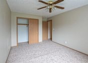 Thumbnail 3 of 10 - A room with a ceiling fan and carpeted floor at Peach Tree Apartments, Ankeny, IA,  50021