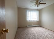Thumbnail 2 of 10 - A room with a ceiling fan and a window with blinds at Peach Tree Apartments, Iowa, 50021