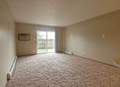 Thumbnail 1 of 10 - an empty living room with a sliding glass door at Peach Tree Apartments, Iowa
