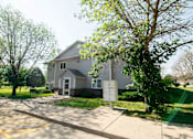 Thumbnail 6 of 10 - A house with a driveway and a sign in front of it at Peach Tree Apartments, Ankeny, IA,  50021