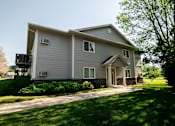 Thumbnail 10 of 10 - A house with a grey siding and a small porch at Peach Tree Apartments, IA, 50021