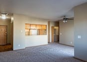 Thumbnail 4 of 12 - an empty living room with a kitchen and a ceiling fan at Sunrise Meadows, Waukee, IA