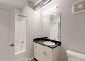 Thumbnail 21 of 31 - A bathroom with a sink, mirror, and toilet at Vue Apartments, IA, 50309