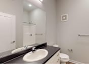 Thumbnail 20 of 31 - a bathroom with a sink and a mirror and a toilet at Vue Apartments, Des Moines, IA