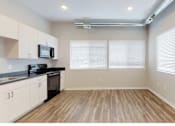 Thumbnail 16 of 31 - a kitchen with white cabinets and a stove and a window at Vue Apartments, Iowa