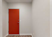 Thumbnail 14 of 31 - a red door in an empty room with white walls and wood floors at Vue Apartments, IA, 50309