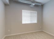 Thumbnail 11 of 31 - a room with a window and a beige carpet at Vue Apartments, Iowa, 50309