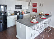 Thumbnail 3 of 31 - a kitchen with an island and a table with chairs at Vue Apartments, Iowa