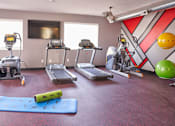 Thumbnail 25 of 31 - a gym with exercise equipment and weights on the floor at Vue Apartments, Des Moines, Iowa