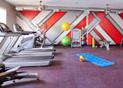 Thumbnail 26 of 31 - a gym with treadmills and other exercise equipment on the floor and a ball at Vue Apartments, Des Moines, Iowa