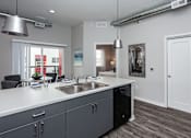Thumbnail 6 of 31 - a kitchen with a large counter top and a sink at Vue Apartments, Des Moines, IA
