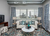 Thumbnail 2 of 31 - a living room with a couch and a table in front of a window at Vue Apartments, IA, 50309