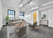 Thumbnail 2 of 50 - A modern living room with a grey carpet and a brown chair at The Des Moines Building Apartments, Des Moines, Iowa