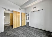 Thumbnail 23 of 50 - A hallway with a carpeted floor and a white wall at The Des Moines Building Apartments, Des Moines, IA