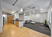 Thumbnail 9 of 50 - A modern open plan office space with a kitchen area at The Des Moines Building Apartments, Des Moines, IA