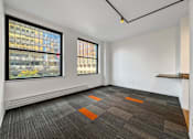 Thumbnail 24 of 50 - A room with a grey carpet and two windows at The Des Moines Building Apartments, Des Moines, Iowa