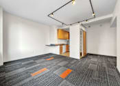 Thumbnail 13 of 50 - A room with a grey carpet and a wooden cabinet at The Des Moines Building Apartments, Des Moines, IA