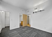 Thumbnail 20 of 50 - A room with a carpeted floor and a wooden door at The Des Moines Building Apartments, Iowa