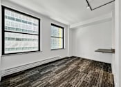 Thumbnail 32 of 50 - A room with a window and a wooden floor at The Des Moines Building Apartments, IA, 50309