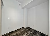 Thumbnail 27 of 50 - A room with a white wall and a brown carpet at The Des Moines Building Apartments, Des Moines, IA