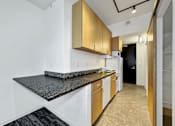 Thumbnail 14 of 50 - A kitchen with white cabinets and a black counter top at The Des Moines Building Apartments, Des Moines