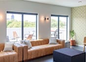 Thumbnail 12 of 26 - a living room with a couch and a table at Rowat Lofts, Iowa, 50309