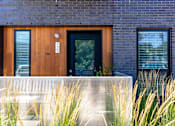 Thumbnail 14 of 26 - the front of a brick house with a wooden door at Rowat Lofts, Iowa, 50309