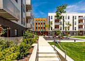 Thumbnail 17 of 26 - a group of modern buildings with a sidewalk and grass at Rowat Lofts, Des Moines  