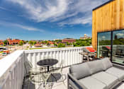 Thumbnail 24 of 26 - a balcony with a couch and a table and chairs at Rowat Lofts, Des Moines, 50309  