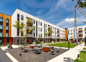 Thumbnail 7 of 26 - a courtyard in front of a row of apartment buildings at Rowat Lofts, Des Moines, IA 50309  