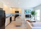 Thumbnail 2 of 26 - a living room with a kitchen and a couch at Rowat Lofts, Des Moines, IA 50309  