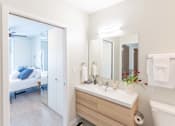 Thumbnail 9 of 26 - a bathroom with a large mirror and a sink at Rowat Lofts, Des Moines Iowa   