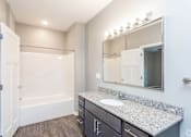 Thumbnail 5 of 32 - A bathroom with a white tub and sink. at The Barclay Apartments, IOWA, 50009