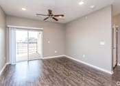 Thumbnail 2 of 32 - an empty living room with a ceiling fan and a sliding glass door at The Barclay Apartments, IOWA