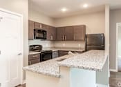 Thumbnail 1 of 32 - a kitchen with granite counter tops and black appliances at The Barclay Apartments, IOWA